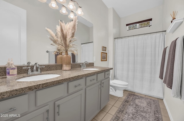 bathroom featuring double vanity, a sink, toilet, and tile patterned floors