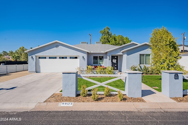 single story home with a garage and a front lawn