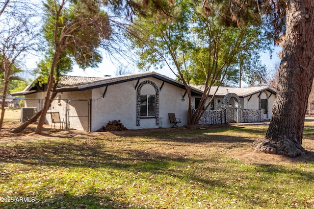 rear view of house with cooling unit and a yard