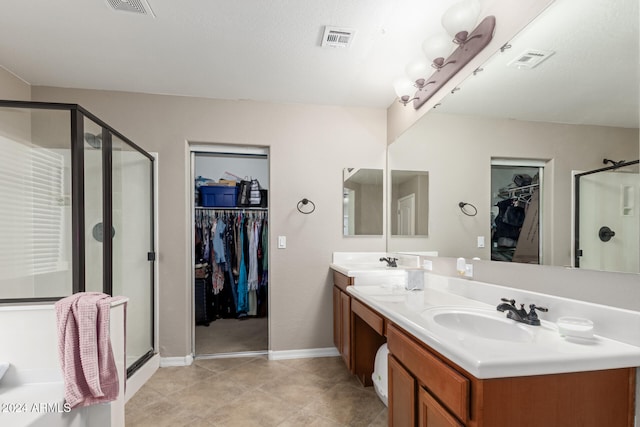 bathroom with tile patterned flooring, vanity, and a shower with door