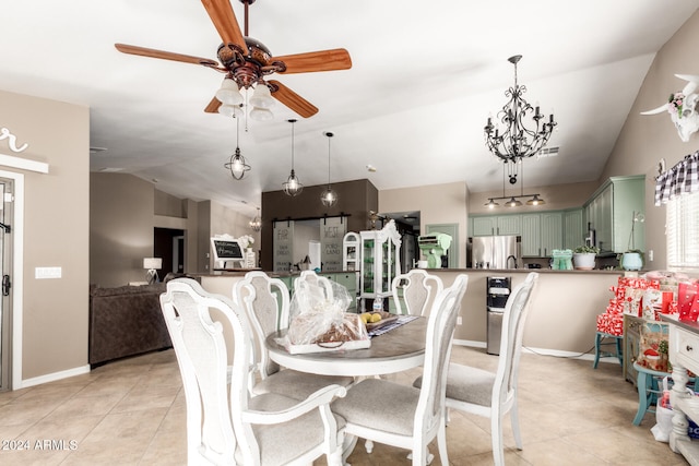 dining space with ceiling fan with notable chandelier, lofted ceiling, and light tile patterned floors