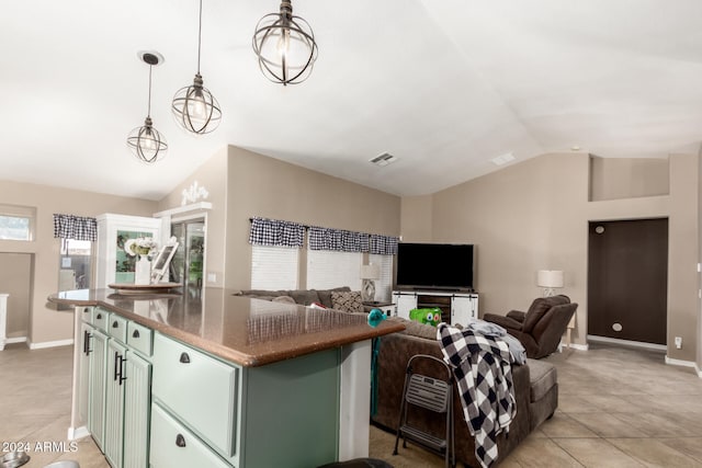 kitchen featuring pendant lighting, light tile patterned floors, lofted ceiling, a kitchen island, and green cabinets