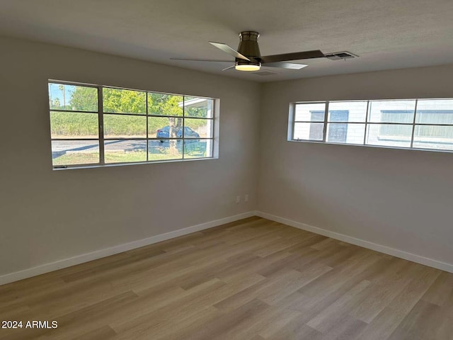 unfurnished room with ceiling fan, plenty of natural light, and light wood-type flooring