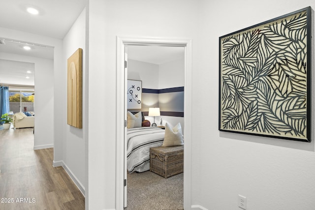 hallway featuring wood finished floors and baseboards