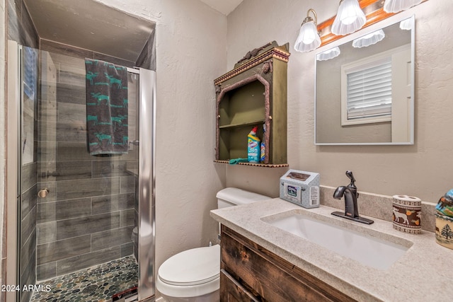 bathroom featuring a shower with shower door, oversized vanity, and toilet