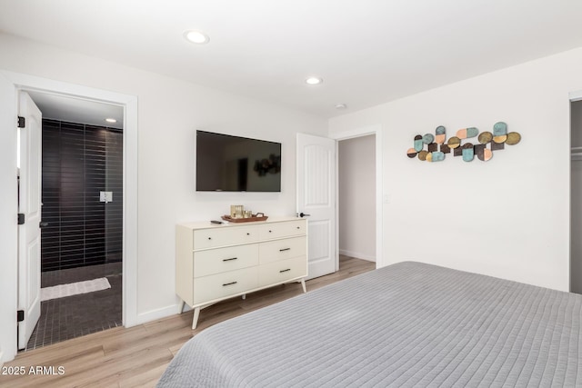 bedroom featuring ensuite bath and light hardwood / wood-style flooring