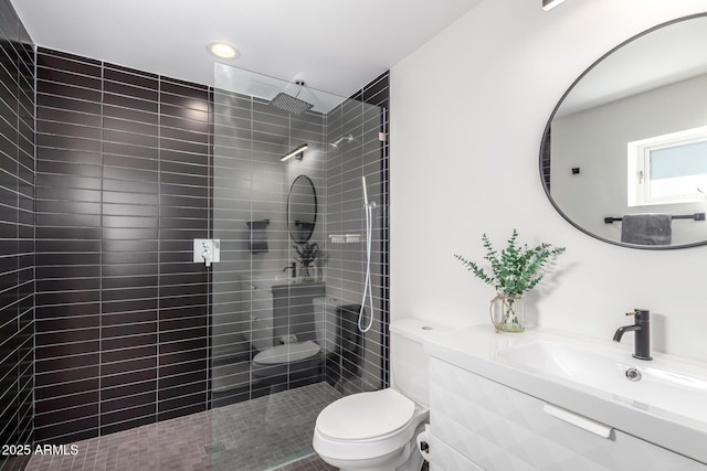 bathroom featuring tiled shower, vanity, and toilet