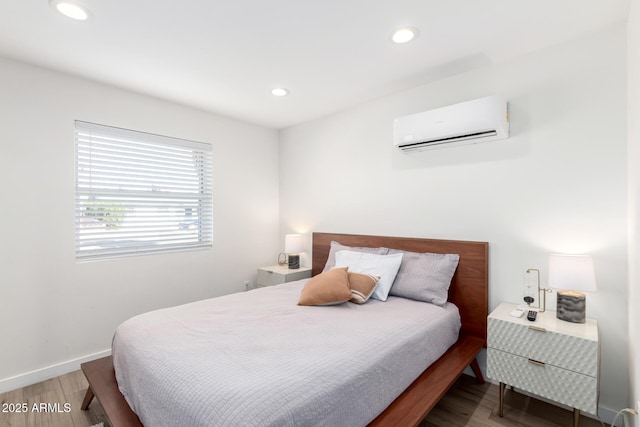 bedroom with hardwood / wood-style floors and a wall mounted AC