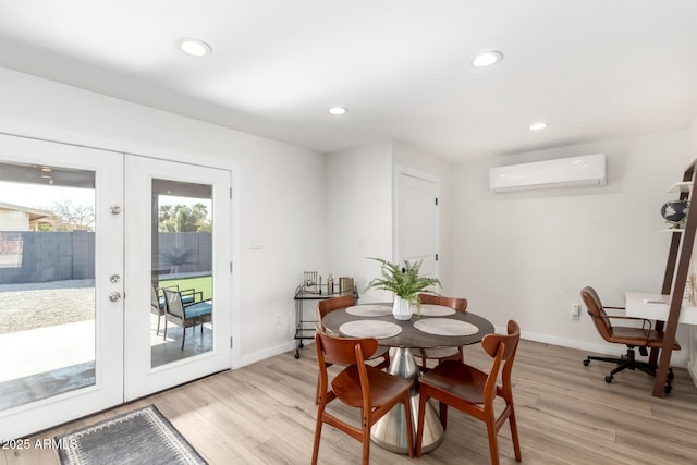 dining room featuring french doors, light hardwood / wood-style floors, and an AC wall unit