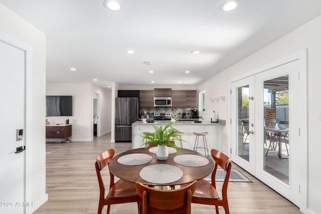 dining area with french doors and light wood-type flooring