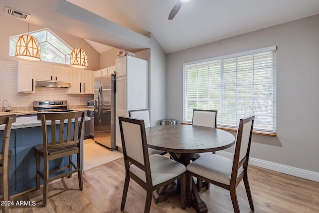 dining area with vaulted ceiling, light hardwood / wood-style floors, and ceiling fan