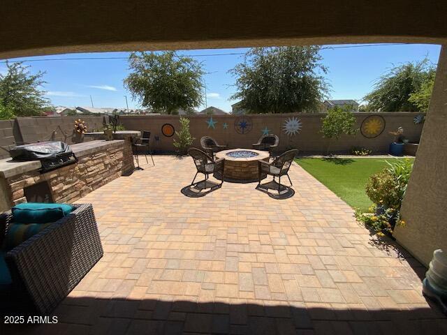 8587 N 171st Dr, Waddell, AZ 85355 - fenced backyard featuring area for grilling, a fire pit, and a patio