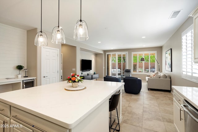 kitchen featuring visible vents, dishwasher, beverage cooler, open floor plan, and a breakfast bar area