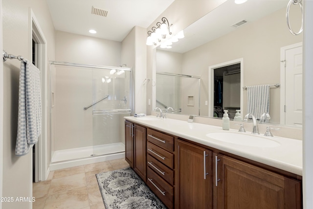 full bath featuring a shower stall, a sink, and visible vents