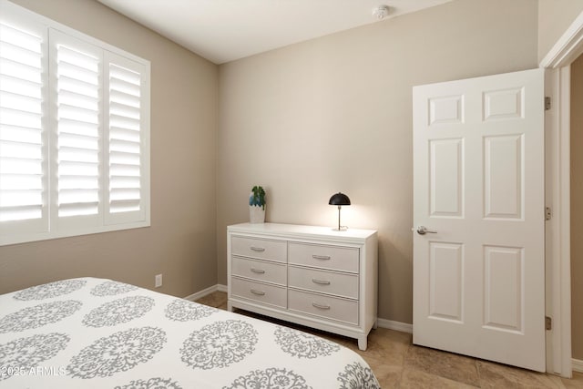 bedroom with light tile patterned floors, multiple windows, and baseboards