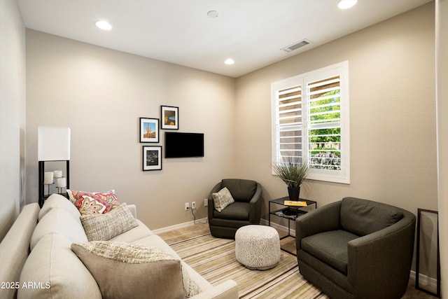 living area featuring recessed lighting, visible vents, and baseboards