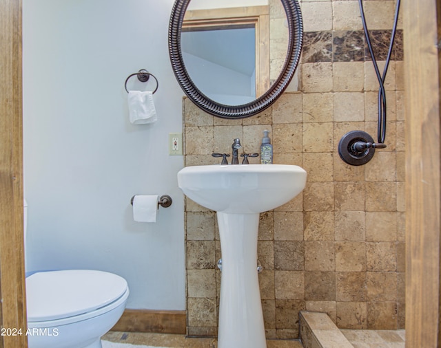 bathroom featuring toilet, tasteful backsplash, sink, and a shower with shower curtain