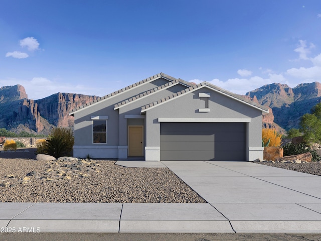 view of front of home featuring a garage, concrete driveway, a mountain view, and stucco siding