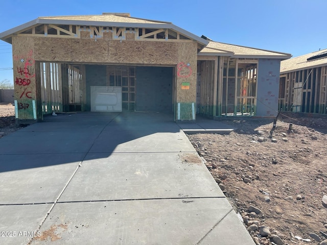 unfinished property featuring driveway and an attached garage