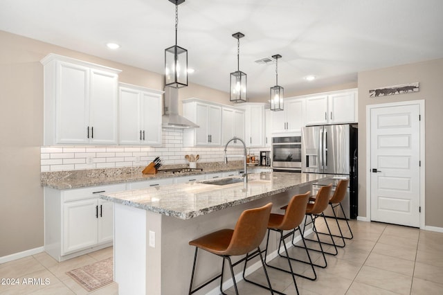 kitchen with white cabinets, a center island with sink, stainless steel appliances, and sink