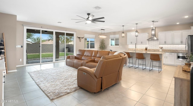 tiled living room with a wealth of natural light, ceiling fan, and sink