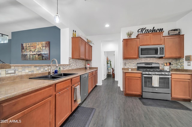 kitchen with sink, dark wood-type flooring, hanging light fixtures, stainless steel appliances, and tasteful backsplash