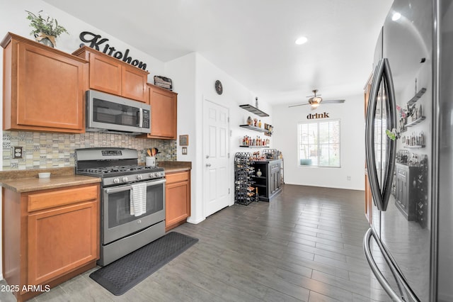 kitchen featuring appliances with stainless steel finishes, dark hardwood / wood-style floors, backsplash, and ceiling fan