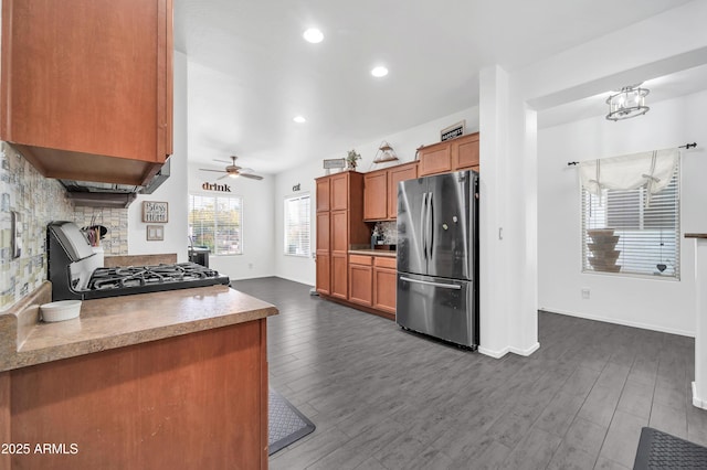 kitchen featuring stainless steel refrigerator, ceiling fan, stove, backsplash, and dark hardwood / wood-style floors