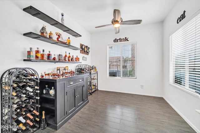 bar with dark hardwood / wood-style floors and ceiling fan