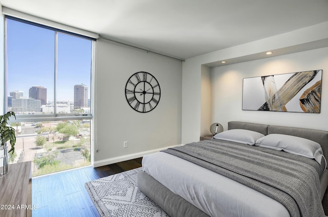 bedroom featuring wood-type flooring and expansive windows