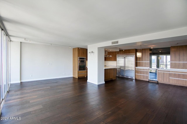 unfurnished living room featuring dark hardwood / wood-style flooring and beverage cooler