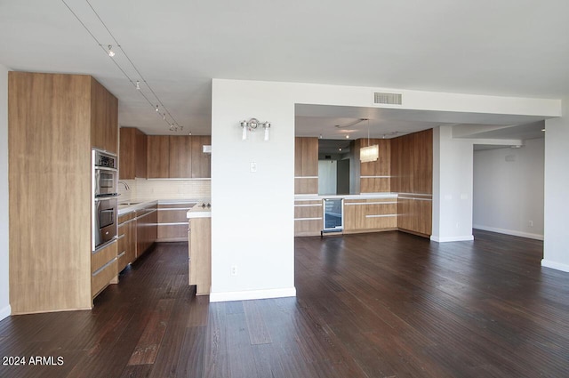 kitchen with tasteful backsplash, beverage cooler, sink, decorative light fixtures, and dark hardwood / wood-style floors