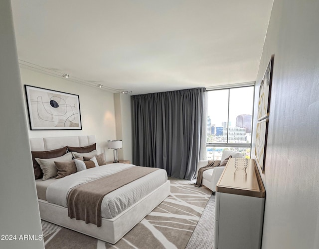 bedroom with light colored carpet and a wall of windows