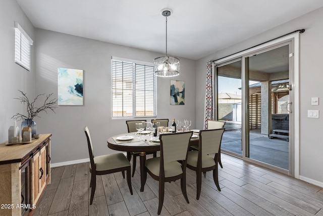 dining space with a notable chandelier, hardwood / wood-style floors, and plenty of natural light