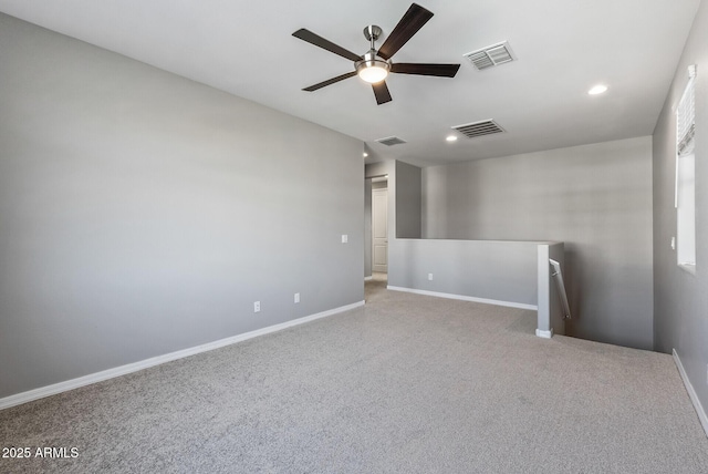 spare room featuring light carpet and ceiling fan