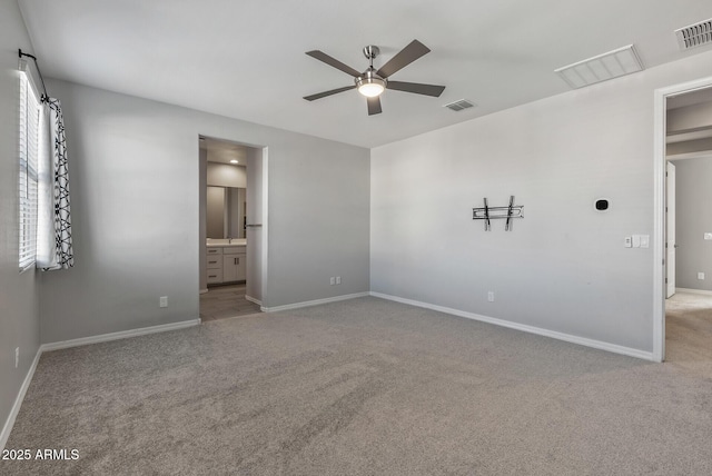 unfurnished bedroom featuring ceiling fan, light carpet, and ensuite bath