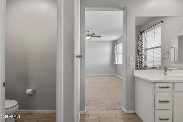 bathroom featuring toilet, vanity, and ceiling fan