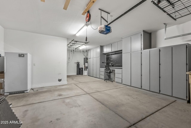 garage featuring a garage door opener and stainless steel refrigerator