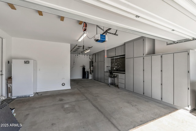 garage featuring white fridge and a garage door opener