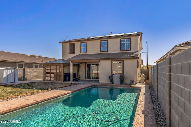 rear view of property with a patio and a fenced in pool