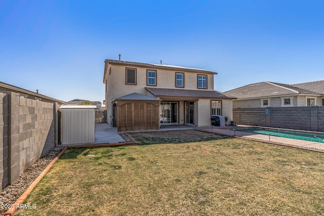 rear view of house with a yard, a fenced in pool, and a patio area