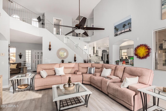 337 E Clairidge Dr, San Tan Valley, AZ 85143 - living room featuring light wood-style floors, stairway, arched walkways, and a ceiling fan