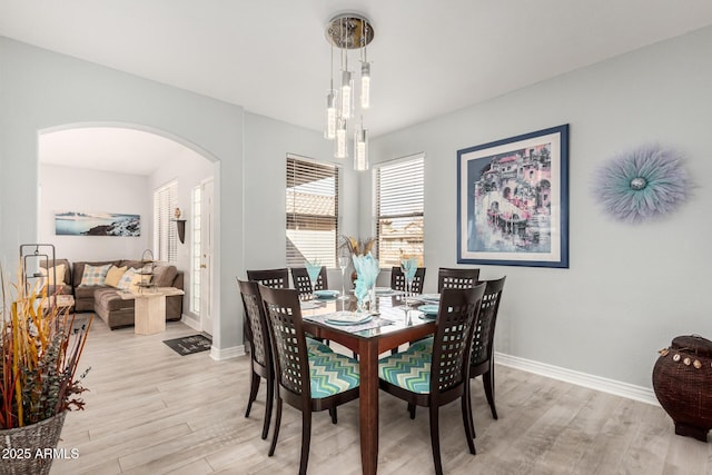 337 E Clairidge Dr, San Tan Valley, AZ 85143 - dining room with arched walkways, light wood-style flooring, and baseboards