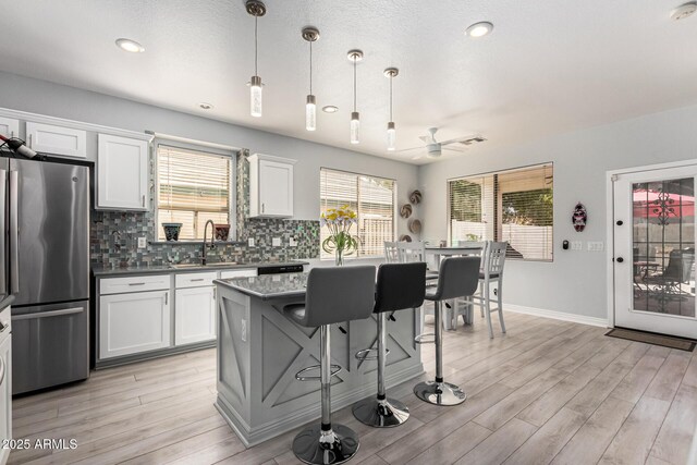 337 E Clairidge Dr, San Tan Valley, AZ 85143 - kitchen featuring freestanding refrigerator, pendant lighting, white cabinets, and decorative backsplash