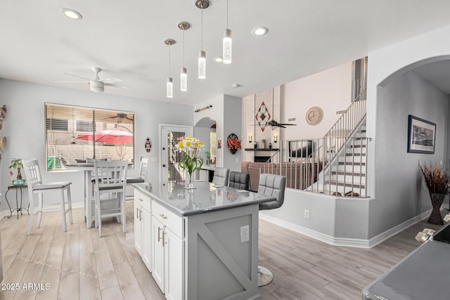 337 E Clairidge Dr, San Tan Valley, AZ 85143 - kitchen with arched walkways, ceiling fan, a kitchen island, white cabinets, and hanging light fixtures