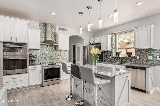 337 E Clairidge Dr, San Tan Valley, AZ 85143 - kitchen with appliances with stainless steel finishes, wall chimney range hood, and white cabinetry