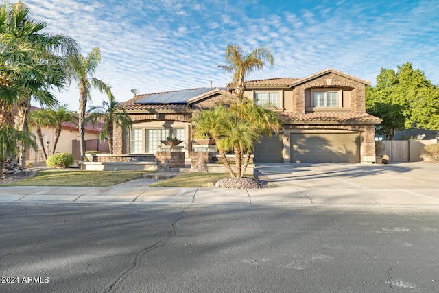 view of front of property featuring solar panels and a garage