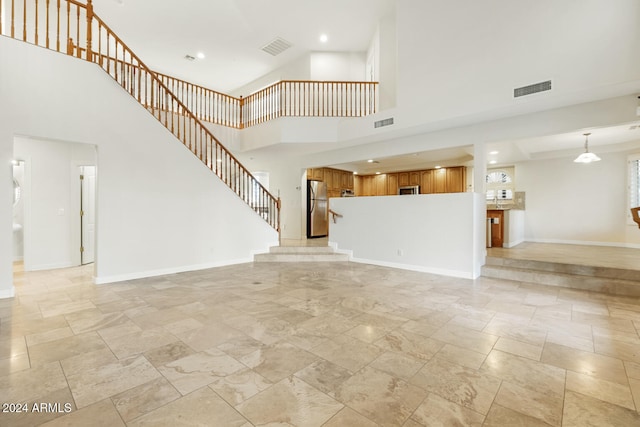 unfurnished living room featuring a high ceiling