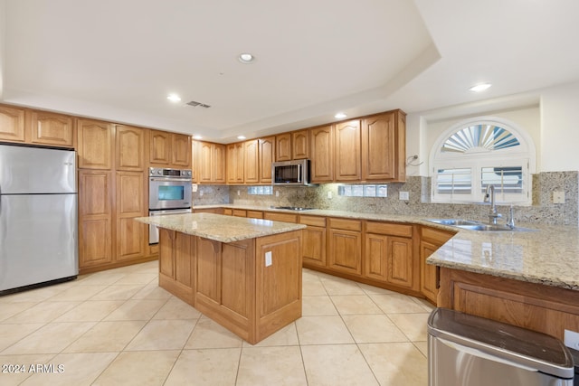 kitchen featuring decorative backsplash, light stone counters, stainless steel appliances, sink, and light tile patterned flooring