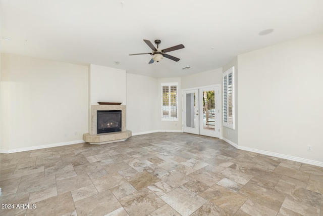 unfurnished living room with ceiling fan and french doors